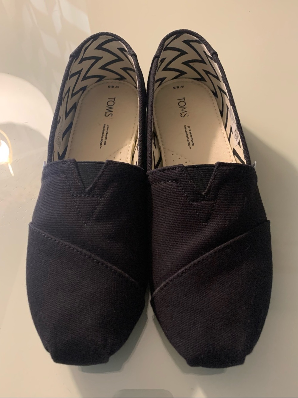Toms Slip-On Canvas Shoes in Black with Light Blue Logo Tab